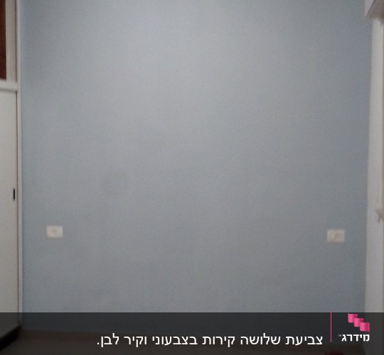 קיר צבוע בצבע תכלת עם פחית צבע על הרצפה